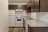 Modern kitchen with sleek brown cabinets, granite countertops, and energy-efficient appliances.