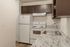 Chic modern kitchen featuring sleek granite countertops, white appliances, and ample cabinetry for stylish living.