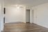 Inviting apartment showcasing a bright, open space with sleek laminate flooring, modern ceiling fan, and a cozy closet for efficient storage.