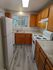 Charming kitchen with warm wooden cabinetry, modern appliances, and a large window offering natural light.