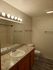 Chic bathroom with elegant lighting, modern fixtures, and granite countertop offering a stylish, inviting ambiance.
