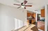 Bright apartment with a sleek interior featuring a modern kitchen, elegant wood cabinetry, and a stylish ceiling fan showcasing comfortable urban living.