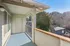 Inviting balcony view with serene greenery and sunlit sky, offering a peaceful outdoor retreat.