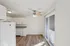 Bright and inviting kitchen area with elegant granite countertops, crisp white cabinetry, and sliding glass door opening to natural light.