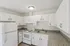 Modern kitchen with sleek white cabinetry, granite countertops, and well-lit interior, perfect for culinary creativity.