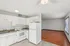 Bright and inviting open-plan kitchen and living area with modern white cabinetry and sleek hardwood floors.