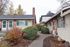 Charming apartment exterior with brick accents, lush gardens, and a welcoming pathway, perfect for a cozy and serene lifestyle.