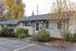 Charming single-story home with brick accents, surrounded by lush gardens and mature trees, offering serene suburban living.
