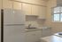 Modern kitchen with sleek cabinetry, marble countertops, and a large fridge offering ample space and functionality.