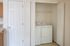 Convenient in-unit laundry space with a modern washer and dryer, tucked neatly behind closet doors in a bright and airy apartment.