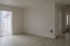 Bright and airy living space with sleek wood flooring, large sliding glass door, and neutral walls.