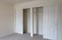 Spacious closet with double sliding doors, featuring ample storage and a sleek design.