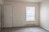 Bright and inviting room with soft carpet flooring, featuring natural light streaming through a neatly covered window, perfect for a cozy and modern living space.