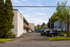 Charming apartment building exterior with ample parking, surrounded by lush greenery and serene neighborhood.
