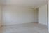 Bright and spacious living area with plush carpeting, ceiling fan, and elegant built-in shelving.