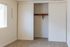 Spacious bedroom with plush carpet and large built-in wardrobe, offering ample storage and natural light.