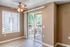 Bright and inviting interior with warm beige walls, a ceiling fan, and sliding glass doors leading to a serene balcony.