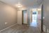 Inviting apartment interior showcasing a cozy, carpeted bedroom with built-in closet and modern lighting, leading to a bright living area with natural light.
