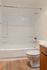Modern bathroom featuring a sleek shower-tub combination, elegant cabinetry, and stylish wood flooring.