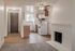 Cozy apartment living area with charming brick fireplace, modern kitchen featuring wooden cabinetry, and elegant lighting.