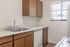 Modern kitchen with sleek countertops, rich wooden cabinets, and large window offering natural light.