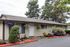Charming single-story home with a well-maintained garden, surrounded by lush trees, offering a tranquil and private setting.