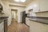 Modern kitchen with elegant white cabinetry, stainless steel appliances, and sleek countertops, offering a spacious and inviting atmosphere.