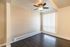 Bright room with elegant ceiling fan, large window with vertical blinds, and sleek dark wood flooring, perfect for modern living.