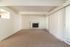 Bright and spacious living room with large windows and a cozy fireplace, perfect for relaxation.
