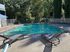 Inviting outdoor pool surrounded by lush greenery, featuring comfortable lounge chairs for relaxation.
