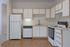 Modern kitchen with sleek white cabinetry, spacious countertops, and essential appliances, perfect for culinary adventures.