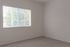 Bright and cozy apartment bedroom with large window, inviting natural light and serene views.
