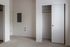 Modern apartment interior featuring a spacious closet with sliding doors and plush carpet flooring, ideal for stylish living.