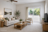 Bright and inviting living room with comfortable seating, modern decor, and a large window opening to a serene outdoor view.