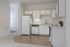 Bright and airy kitchen with white cabinetry, modern appliances, and a stylish blend of carpet and hardwood flooring.