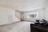 Bright and inviting living room with plush carpeting, a cozy sofa, and large window providing ample natural light.