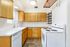Bright and inviting kitchen with modern appliances, wooden cabinetry, and ample counter space.