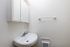 Bright and modern bathroom with a sleek wall-mounted sink, mirrored cabinet, and convenient towel bar.