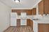 Modern kitchen with sleek wooden cabinets, white appliances, and elegant countertops, ideal for cooking and entertaining.