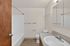 Modern bathroom with sleek fixtures, elegant mirror, and inviting bathtub, offering a serene space for relaxation.