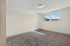 Bright and spacious bedroom with plush carpet flooring and a large window offering natural light.