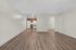 Spacious open-plan apartment with elegant wood flooring, featuring a cozy kitchen with wood cabinets and modern appliances.