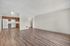 Spacious open-concept living area featuring elegant wood flooring and a modern kitchen with sleek white appliances.