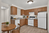 Charming kitchen featuring warm wooden cabinetry, sleek appliances, and a cozy dining area.
