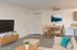 Charming living and dining area in a virtually staged apartment, featuring modern d&eacute;cor, a cozy sitting space, and elegant wooden furniture for a welcoming atmosphere.