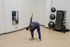 Modern fitness room with integrated SmartMat showcasing dynamic exercise poses, featuring a person engaged in stretching on a sleek wooden floor.