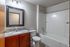 Contemporary bathroom with elegant granite countertop, sleek bathtub, and modern lighting.