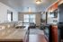 Inviting modern apartment with sleek kitchen, polished granite countertops, and cozy living area featuring natural light through large windows.