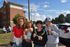 Vibrant group enjoying a sunny day outdoors with smiles and ice cream in front of a modern apartment building.
