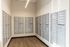 Modern apartment mailroom with sleek, organized mailboxes and warm wood flooring.